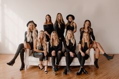 a group of beautiful women sitting next to each other on top of a white couch