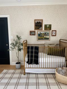 there is a baby crib in the room with pictures on the wall