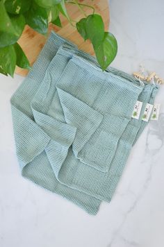 a green cloth sitting on top of a table next to a potted plant and a wooden cutting board