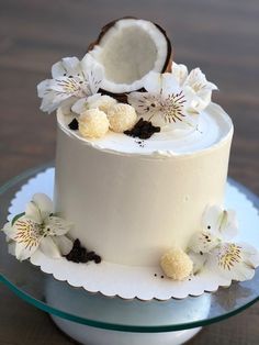 a white cake with flowers and a coconut on top