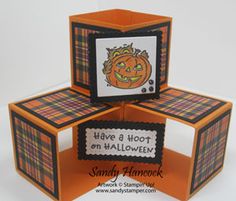 an orange and black card with a pumpkin on it, in the middle of three blocks