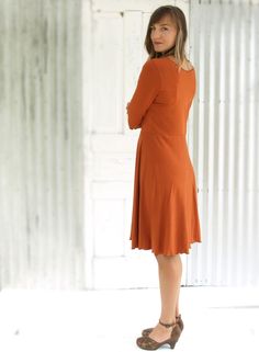 "The Oracle Dress is flattering yet modest, an ideal dress for a casual or professional look. You will want one in several different colors for sure. It is so soft and stretchy, and so comfortable you may never want to take it off. * Mid length dress * 3/4 sleeves * Scoop neck * Faux wrap skirt * Lettuce hem finishing * 25\" from waist to hem (can be customized) COLOR Pictured in Rust. See images and drop-down menu for all color options. SIZES Made to order in sizes XS-3X or Custom. See images f Fall A-line Midi Dress With Flattering Silhouette, Modest Fitted A-line Long Sleeve Dress, Flowy Orange Midi Dress Knee-length, Orange Flowy Knee-length Midi Dress, Orange Flowy Midi Dress, Fall Knee-length Dress With Flattering Silhouette, Knee-length Fall Dresses With Flattering Silhouette, Fall Dresses With Flattering Silhouette, Knee-length, Flattering Knee-length Fall Dress