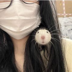 a woman wearing a face mask holding a rodent