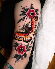 a woman's arm with a butterfly and flowers tattoo design on the left forearm