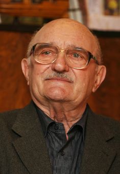 an older man wearing glasses and a suit