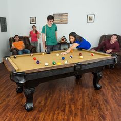 a group of people playing pool in a living room