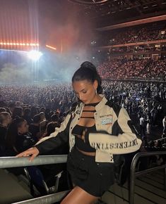 a woman standing on top of a metal rail in front of a crowd