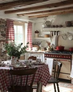 a kitchen with an oven, table and chairs next to the stove in front of it