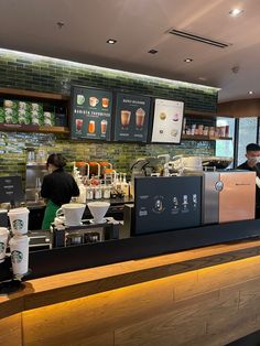 people are sitting at the counter in a coffee shop with menus on the wall