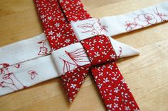 a red and white piece of fabric on top of a wooden table