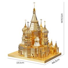 a wooden model of a church with steeples and crosses on the roof, in gold