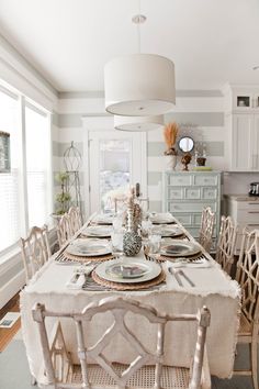 a dining room table is set with plates and silverware