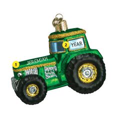 an ornament shaped like a green tractor with gold trimmings on it