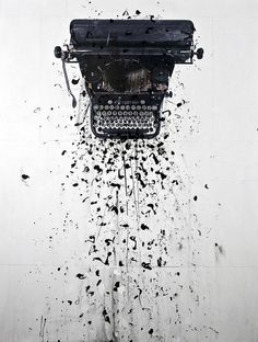 an old fashioned typewriter is splattered with black ink on a white wall