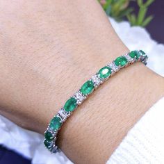 This elegant bracelet has 9.56 ct of green emeralds and 0.65 ct of round G-SI diamonds in 14K white gold setting. All our jewelry pieces come with an appraisal and replacement value guarantee. Carat Range 10+ Color G-H, Green Cut Oval, Round Clarity SI GemStone Diamond - April, Emerald - May Material 14k White Gold Shop Bracelet, Gemstones, Prong, Anniversary, Tennis Bracelets Green Diamond Tennis Bracelet For Formal Occasions, Formal Green Diamond Tennis Bracelet, Green Emerald Diamond Bracelet For Anniversary, Green Bangle Tennis Bracelet For Formal Occasions, Formal White Gold Emerald Tennis Bracelet, Green Formal Tennis Bangle Bracelet, Formal Green Diamond Bracelet With Gemstone, Green Diamond Round Bracelet, Green Oval Diamond Tennis Bracelet