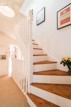 there is a vase with yellow flowers on the stairs in this house's entryway