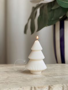 a small white christmas tree sitting on top of a table