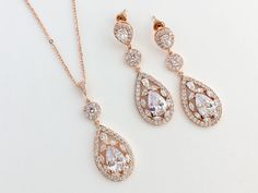 Super sparkely clear cubic zirconia bridal teardrop jewelry set in rose gold plated brass setting. This set includes: # Super sparkly earrings # I've created these truly amazing earrings with delicately detailed clear cubic zirconia teardrop that dangles from a cubic zirconia detailed teardrop ear stud and a halo connector. Total length of the earrings is 4.8 cms. # Super sparkly necklace# Necklace pendant features delicately detailed super sparkly teardrop with clear cubic zirconia crystals and Rose Gold Teardrop Wedding Jewelry Sets, Rose Gold Teardrop Jewelry Sets For Wedding, Silver Drop Earrings Wedding, Rose Gold Bridal Jewelry Set, Rose Gold Bridesmaid Jewelry, Rose Gold Wedding Set, Gold Wedding Set, Gold Bridesmaid Jewelry, Gold Bridal Jewelry