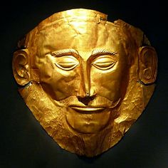 a golden mask with eyes closed on a black background in the shape of a man's head