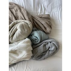 an unmade bed covered in blankets and blankets on top of it, with the sheets pulled back