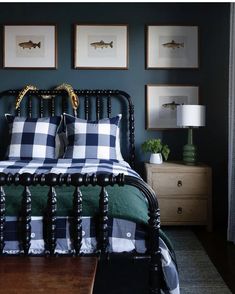 a bed room with a neatly made bed and pictures on the wall