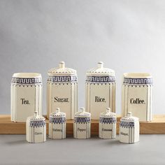 five ceramic canisters are lined up next to each other