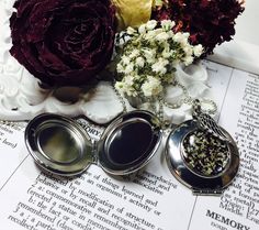 three silver lockes sitting on top of an open book with flowers in the background