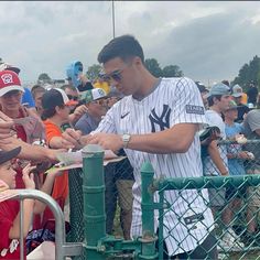 a baseball player signing autographs for fans