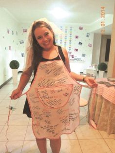 a woman holding up a large apron with writing on it