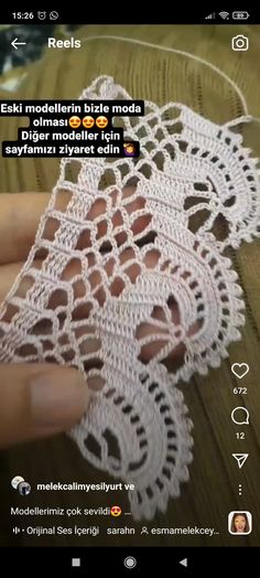 someone is crocheting an object on their cell phone, and it looks like they are