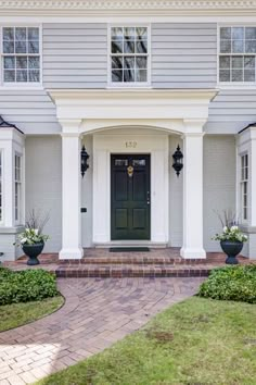 the front entrance to a large gray house