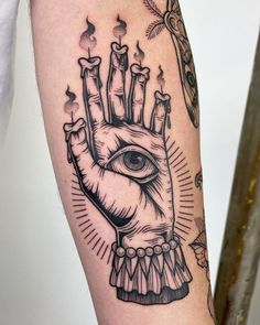 a hand with an all seeing eye on it and candles in the palm is shown