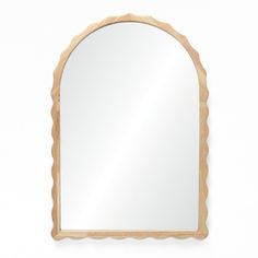 a wooden mirror with scalloped edges on a white wall, in the shape of an arch