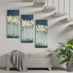 three paintings hanging on the wall next to a couch with a plant in front of it