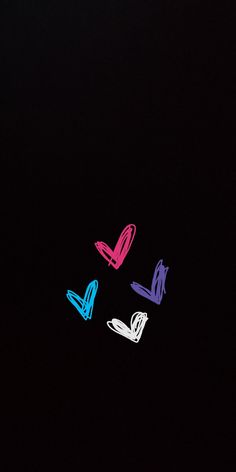 four different colored objects are in the dark, with one black background and three white ones