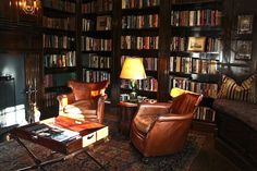 a living room filled with furniture and bookshelves covered in lots of bookcases