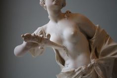 a statue of a woman holding her hands out in front of the viewer's face