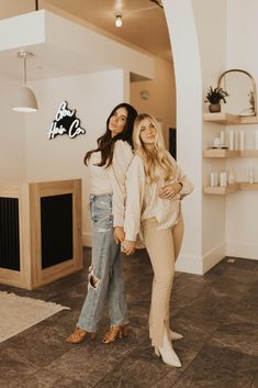 two women standing next to each other holding hands