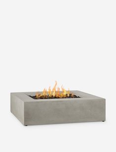 a concrete fire pit sitting on top of a white surface with flames coming out of it