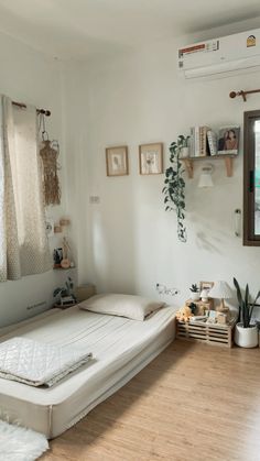 a bed sitting in a bedroom on top of a hard wood floor next to a window