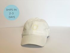 + Embroidered sunshine baseball hat + 100% cotton + Relaxed fit and washed pigment look + Adjustable strap with metal closure in the back + Hat color options: white, black, light grey, grey, burgundy, gold, and light blue + Multiple thread color options (see chart in photos) + Embroidered sunshine image size is about 1.5 inches on hat ☀ Example in listing is white hat with sunflower thread → To see our other embroidered hat products, click here: https://etsy.me/3Mh2NRo Embroidered Sunshine, Gold And Light Blue, Cloud Design, Sun Design, Mom Hats, Clouds Design, Sun Designs, Embroidered Hat, Embroidered Baseball