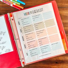 a weekly planner with markers and pencils next to it on top of a wooden table