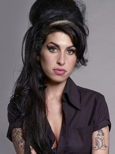 a woman with long black hair and tattoos on her arm, posing for a photo