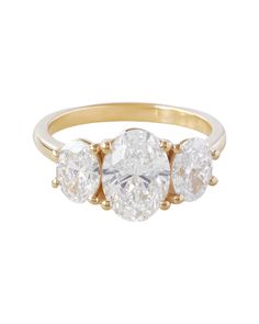 three stone diamond ring in yellow gold with diamonds on the sides and an oval shaped center