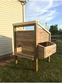 a wooden bed sitting in the grass next to a house