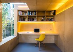 a yellow chair sitting in front of a wooden desk