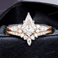 an engagement ring with a pear shaped cut diamond surrounded by small white and rose gold diamonds