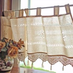 a vase filled with flowers sitting on top of a wooden table next to a window