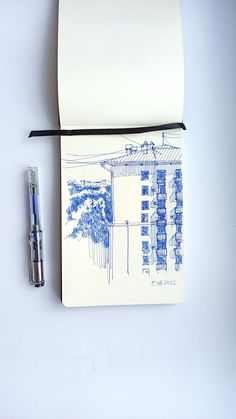 an open notebook with blue ink on it next to a fountain pen and paper roll