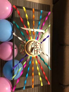 a birthday cake surrounded by balloons and streamers